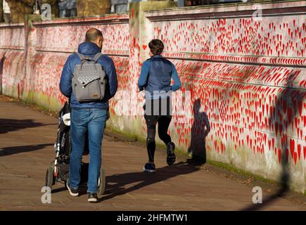 London, Großbritannien. 17th Januar 2022. Menschen, die das milde Wetter genießen, machen einen Spaziergang entlang der National Covid Memorial Wall. Die Wand ist mit 150.000 roten Herzen geschmückt, was ungefähr der Anzahl der Todesfälle von Covid-19 entspricht, als sie im März 2021 begann. Die Mauer befindet sich neben dem St. Thomas's Hospital. Kredit: Mark Thomas/Alamy Live Nachrichten Stockfoto