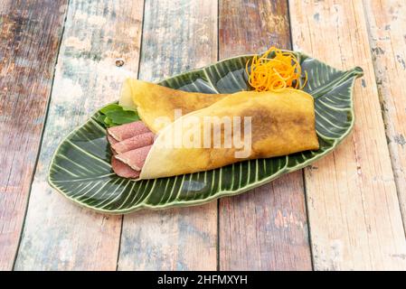 Europäisches Rezept französischer Herkunft aus Weizenmehl, mit dem ein scheibenförmiger Teig hergestellt und in diesem Fall mit Roastbeef und Rocke gefüllt wird Stockfoto