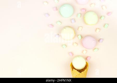 Grundrisse mit Waffelkegel und farbigen Marschmörmeln auf pastellfarbenem Hintergrund Stockfoto