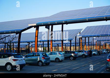 Sonnenkollektoren auf einem Parkplatz. Unternehmen installieren erneuerbare Energiequellen, um ihre CO2-Bilanz zu reduzieren. Padua, Italien - Januar 2022 Stockfoto