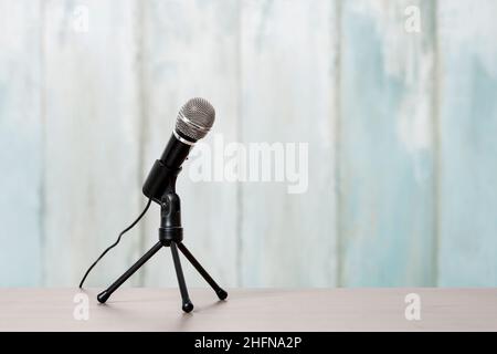 Mikrofon auf blauem Holzhintergrund isoliert. Grafikressourcen Stockfoto