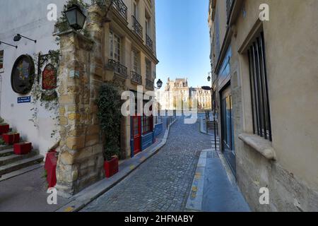 Paris, Frankreich - 3. April 2021: Kleine gemütliche Straße mit Rathaus im Hintergrund in Paris Stockfoto