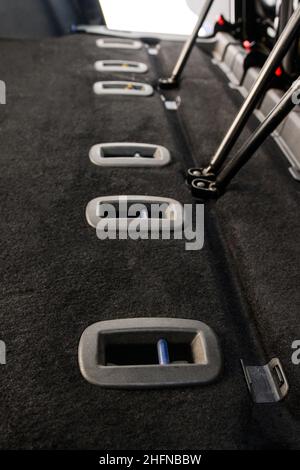 Gepflegter und sauberer Innenraum, graue Stoffsitze, gefaltete Sitze. Befestigung der Autositze. Stockfoto