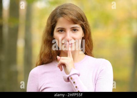 Vorderansicht Porträt einer jungen Frau, die in einem Wald um Ruhe bittet Stockfoto