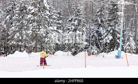 Snowboarder erklimmen die Piste mit dem Seillift. Winter Wald Hintergrund. Winter aktiv Outdoor Sport Erholung. WEBBANNER-Format Stockfoto