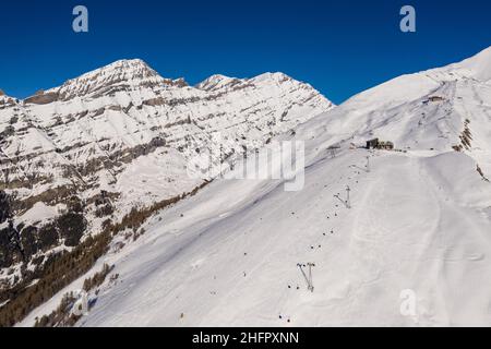 Luftaufnahme des Skigebiets Leukerbad und der Seilbahnstation in den alpen im Kanton Wallis in der Schweiz an einem sonnigen Wintertag. Stockfoto