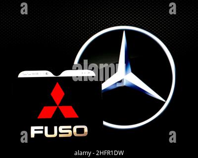 In dieser Abbildung ist das Logo der Mitsubishi Fuso Truck and Bus Corporation auf einem Smartphone-Bildschirm mit dem Logo der Daimler AG im Hintergrund zu sehen. Stockfoto