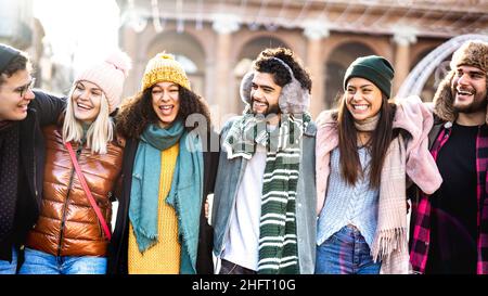 Fröhliche Studenten gehen am sonnigen Tag in die europäische Stadt - Lifestyle-Konzept der nächsten Generation mit multirassischen jungen Menschen, die Wintermode tragen Stockfoto