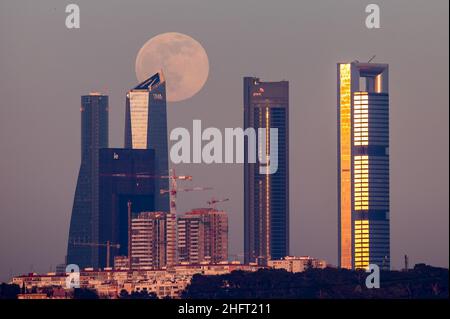 Madrid, Spanien. 17th Januar 2022. Der Vollmond im Januar steigt über den Wolkenkratzern des Geschäftsviertels Four Towers von Madrid Credit: Marcos del Mazo/Alamy Live News Stockfoto