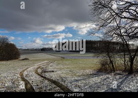 Blick auf ein leicht schneebedecktes Feld im Winter mit pastellfarbenen Farben Stockfoto