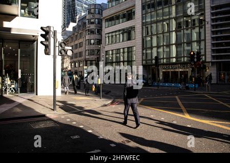 London Pendler an einem frischen Wintermorgen machen sich auf den Weg in die City of London, während die Sonne aufgeht und Arbeiter in ihr Büro zurückkehren, Januar 2022 Stockfoto