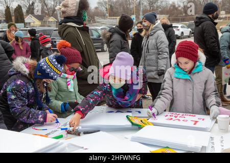 Royal Oak, Michigan, USA. 17th Januar 2022. Kinder machen Schilder, die sie tragen sollten, bevor sie an einem marsch zum Gedenken an den Martin Luther King Jr. Day teilnehmen. Die Veranstaltung war ein Projekt der Schulbezirke in Royal Oak und Berkley, zwei überwiegend weißen Vororten von Detroit. Kredit: Jim West/Alamy Live Nachrichten Stockfoto