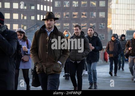 London Pendler an einem frischen Wintermorgen machen sich auf den Weg in die City of London, während die Sonne aufgeht und Arbeiter in ihr Büro zurückkehren, Januar 2022 Stockfoto