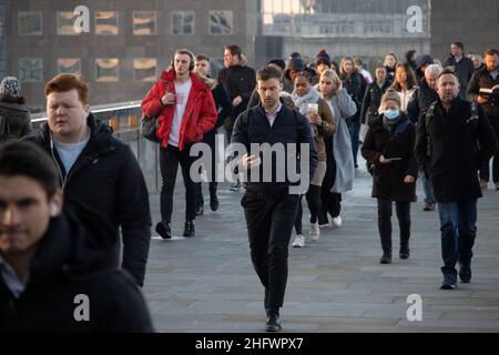 London Pendler an einem frischen Wintermorgen machen sich auf den Weg in die City of London, während die Sonne aufgeht und Arbeiter in ihr Büro zurückkehren, Januar 2022 Stockfoto