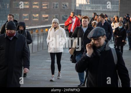 London Pendler an einem frischen Wintermorgen machen sich auf den Weg in die City of London, während die Sonne aufgeht und Arbeiter in ihr Büro zurückkehren, Januar 2022 Stockfoto