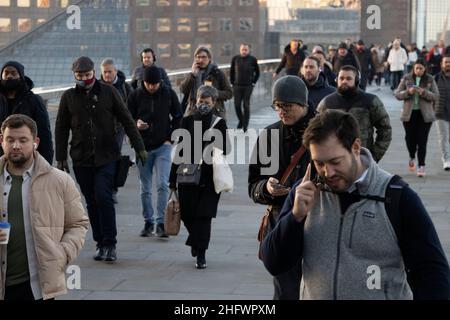 London Pendler an einem frischen Wintermorgen machen sich auf den Weg in die City of London, während die Sonne aufgeht und Arbeiter in ihr Büro zurückkehren, Januar 2022 Stockfoto