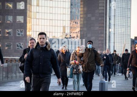 London Pendler an einem frischen Wintermorgen machen sich auf den Weg in die City of London, während die Sonne aufgeht und Arbeiter in ihr Büro zurückkehren, Januar 2022 Stockfoto