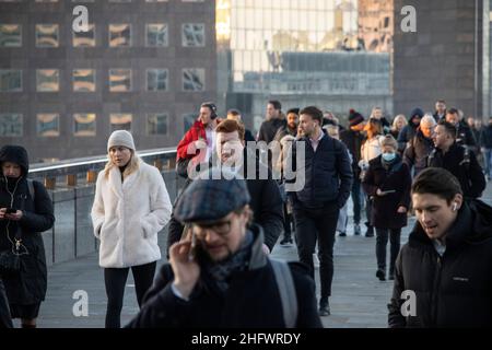 London Pendler an einem frischen Wintermorgen machen sich auf den Weg in die City of London, während die Sonne aufgeht und Arbeiter in ihr Büro zurückkehren, Januar 2022 Stockfoto