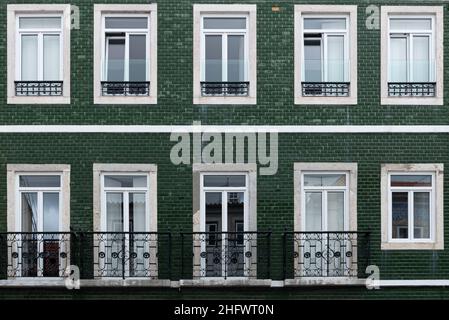 Architektonisches Detail Nahaufnahme der traditionellen grünen Fliesenfassade des Wohnhauses mit gusseisernen Geländerbalkonen in Lissabon Portugal Stockfoto