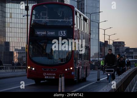 London Pendler an einem frischen Wintermorgen machen sich auf den Weg in die City of London, während die Sonne aufgeht und Arbeiter in ihr Büro zurückkehren, Januar 2022 Stockfoto