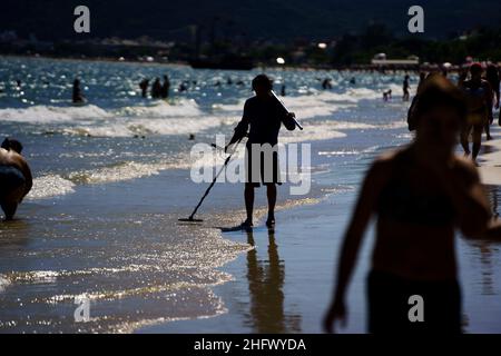 Canasvieiras, Brasilien. 16th Januar 2022. Ein Mann geht mit einem Metalldetektor am Strand entlang. Während der Badesaison suchen Schatzsucher am Strand nach verlorenen und wertvollen Gegenständen. Quelle: Diorgenes Pandini/dpa/Alamy Live News Stockfoto