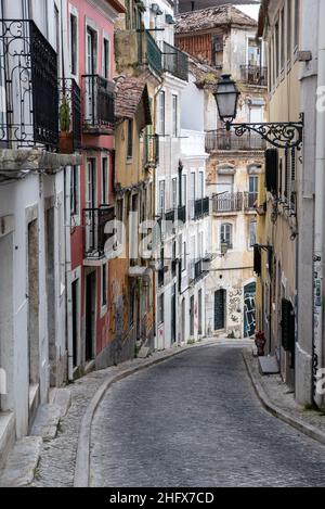Reihe von traditionellen städtischen Wohnhäusern in hügeliger Nachbarschaft Kopfsteinpflasterstraße im Stadtteil Bica in Lissabon Portugal Stockfoto