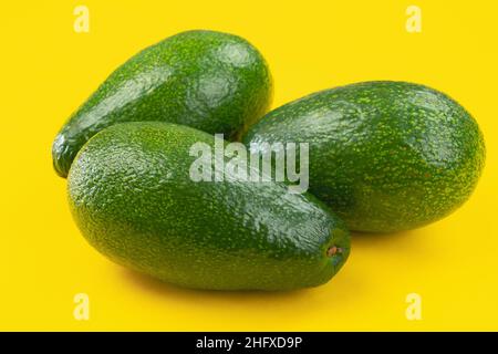 Drei Avocados auf gelbem Hintergrund Stockfoto