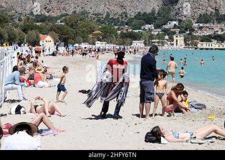 Foto Alberto Lo Bianco/LaPresse 16-05-2021 Mondello (PA) Cronaca A Palermo nell’ultima domenica di zona arancione si respira già aria d’estate. Scaduta l’ordinanza del sindaco Leoluca Orlando che vietava l’Accesso ai litorali nel weekend, molti palermitani hanno così approfittato del bel Tempo per recarsi in spiaggia a Mondello. Nella foto: spunta pure il vucumprà Foto Alberto Lo Bianco/LaPresse 16. Mai 2021 Mondello (PA) Nachrichten Letzter Tag der orangen Zone in Sizilien. In Mondello, 30 Grad und der Strand ist voller Menschen. Stockfoto