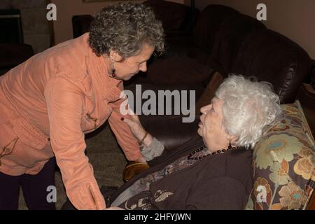 Tochter im tiefen Gespräch mit ihrer Mutter, die bequem in einem Seniorenwohnheim lebt. Downers Grove Illinois IL USA Stockfoto