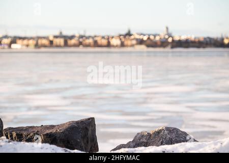 Helsinki / Finnland - 13. JANUAR 2022: Verhockte Silhouette der Innenstadt von Helsinki auf der anderen Flussseite. Stockfoto