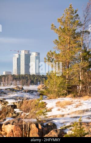 Helsinki / Finnland - 13. JANUAR 2022: Drei Wolkenkratzer aus einem bewaldeten Gebiet. Stadtansicht einer Stadt von weitem. Stockfoto