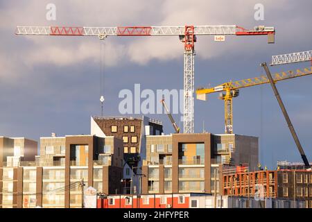 Helsinki / Finnland - 13. JANUAR 2022: Blick auf eine moderne Baustelle mit großen Kranen. Stockfoto