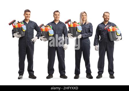 Gruppe von jungen professionellen Reinigungskräften in Uniformen, die Eimer mit Reinigungsmitteln auf weißem Hintergrund isoliert halten Stockfoto