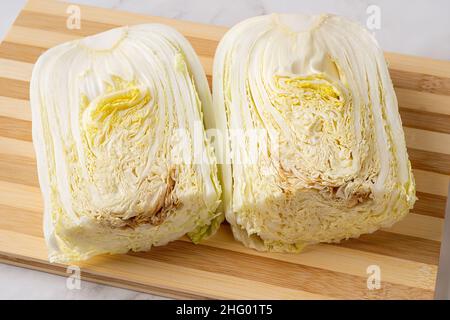 Das verfaulende Innere des napakohls. Verfaulter chinakohl auf einem Schneidebrett halbieren. Der Kohlkopf verdirbt von innen. Das Essen war verdorben. Stockfoto