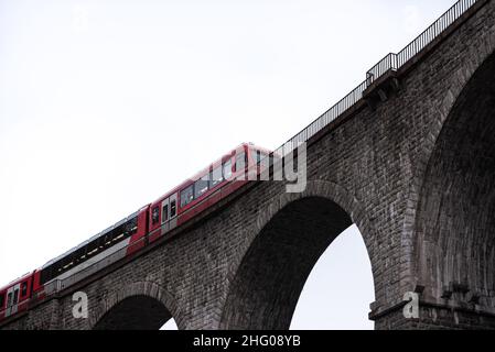 Mont Blanc Express-Personenzug über Steinbogen- und Pfeilereisenbahn-Brücke gegen den Himmel mit hoher Beleuchtung in Chamonix Frankreich Stockfoto