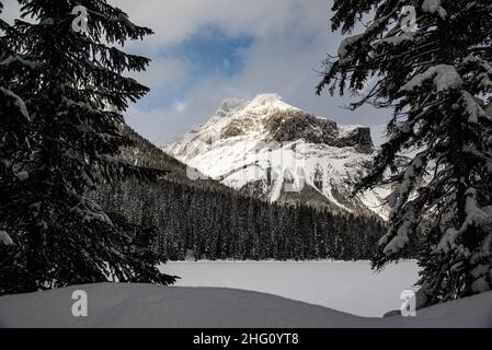 Yoho National Park, Kanada - 23 2021. Dez.: Gefrorener Emerald Lake versteckt sich im Winterwald umgeben von rocky mountains im Yoho National Park Stockfoto