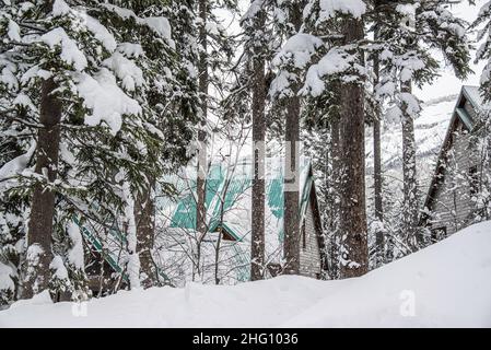 Yoho National Park, Kanada - 23 2021. Dez.: Holzhütte und cabane an der Seite des Frozen Emerald Lake, versteckt im Winterwald, umgeben von rockies Mount Stockfoto