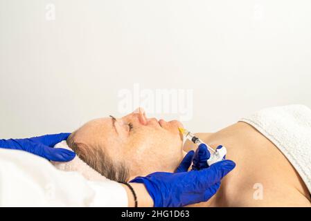 Botulinumtoxin-Injektion auf die Augenpartie, zum Heben der Haut um die Augen, Mesotherapie. Stockfoto