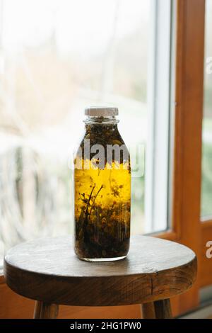 Ein Glas Öl mit Pflanzen und Kräutern Stockfoto