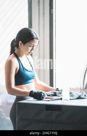 Frau, die ihre Fortschritte im Fitnessstudio in Bangkok aufgezeichnet hat Stockfoto