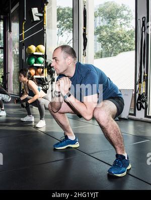 Paar, die Aufwärmprupps im Fitnessstudio in Bangkok durchführen Stockfoto