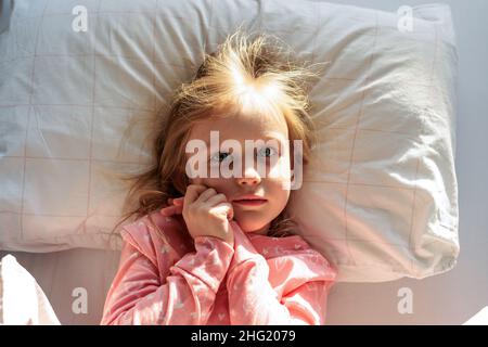 Das kleine Mädchen im Schlafanzug wachte am Morgen auf Stockfoto