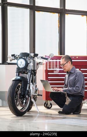 Techniker überprüft Elektromotorrad in der Werkstatt Stockfoto