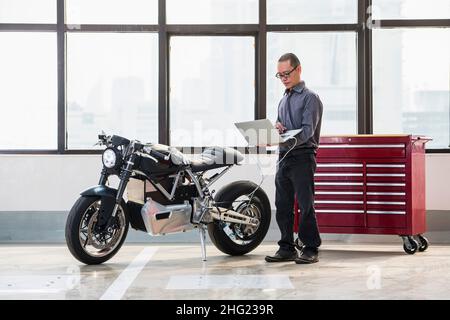 Techniker überprüft Elektromotorrad in der Werkstatt Stockfoto