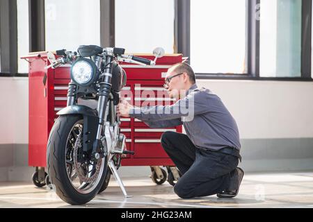 Techniker überprüft Elektromotorrad in der Werkstatt Stockfoto