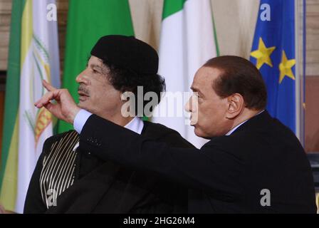 Der italienische Premier Silvio Berlusconi, rechts, spricht mit dem libyschen Führer Moammar Gadhafi vor dem Beginn einer gemeinsamen Pressekonferenz in der römischen Villa Madama ist Gadhafi zu einem dreitägigen offiziellen Besuch in Italien. Stockfoto