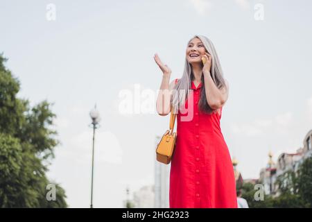 Foto von reifen attraktive asiatische Frau glücklich positive Lächeln Spaziergang Park sprechen Handy Gespräch im Freien Stockfoto