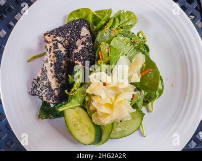 Der Thunfischsalat von AHI wird auf einem Bett aus gemischtem Gemüse mit Gurken- und Karottennudeln, Paprika, Avocado und Wontons gebraten, die alle in einer Sesamung geschmortelt werden Stockfoto