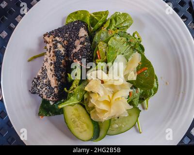 Der Thunfischsalat von AHI wird auf einem Bett aus gemischtem Gemüse mit Gurken- und Karottennudeln, Paprika, Avocado und Wontons gebraten, die alle in einer Sesamung geschmortelt werden Stockfoto