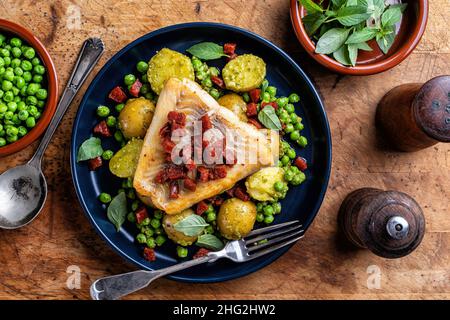 Köstlicher, in der Pfanne gebratener Kabeljau mit Chorizo-Wurst und Pesto-Erbsen mit Babykartoffeln. Stockfoto